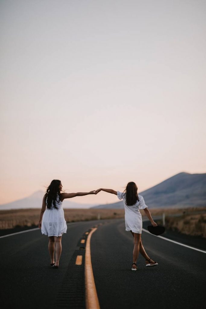 two girls on a road at dusk